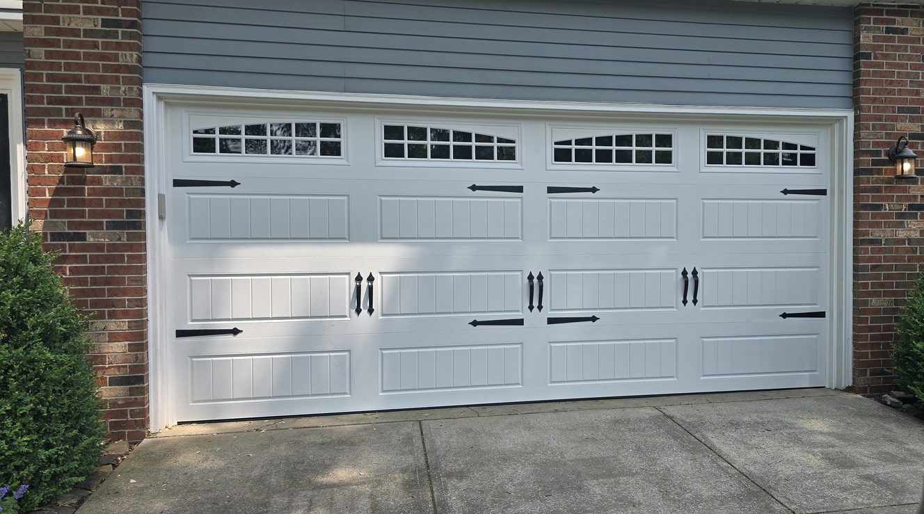 White carriage style double garage door with windows and black hardware
