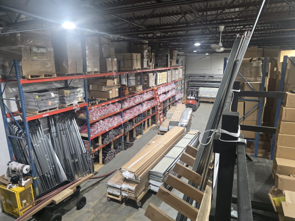 Garage door tracks, springs and parts stocked on warehouse racks at Proactive Garage Door Repair