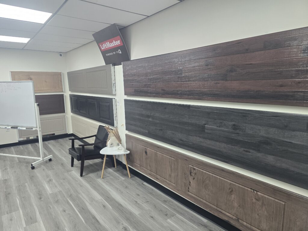Wall of garage door finish samples and a LiftMaster sign at Proactive Garage Door Repair