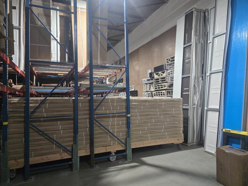 Racks of new garage door sections at the Proactive Garage Door Repair warehouse