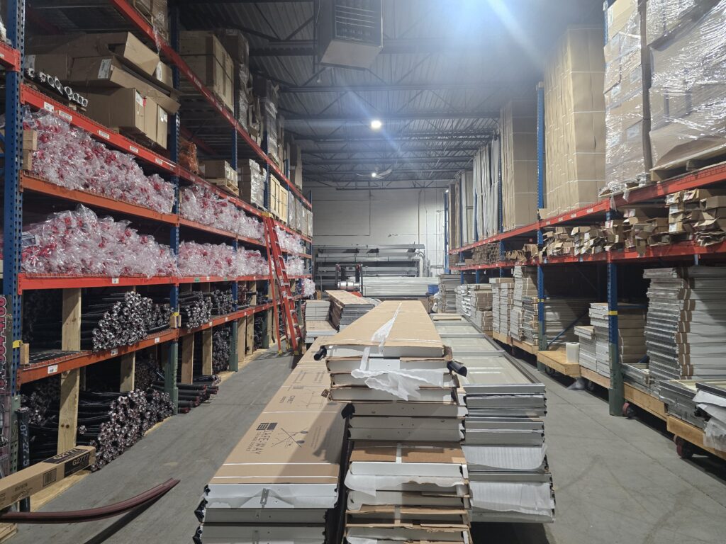 Shelves of garage door springs, parts and new door sections in the Proactive warehouse