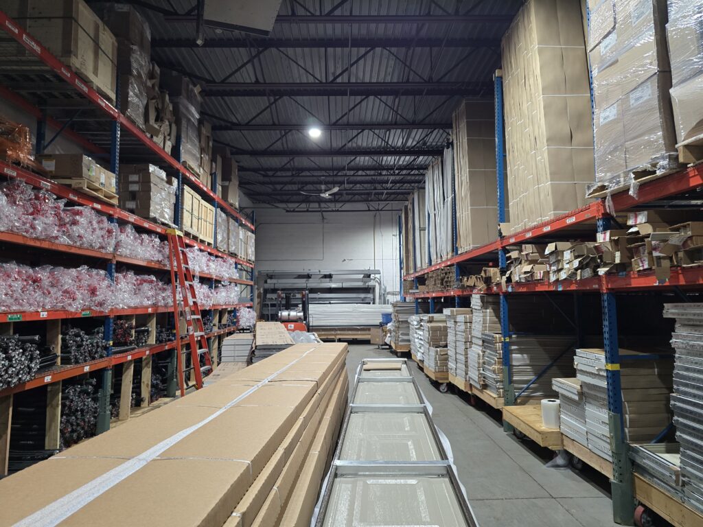 Aisle of garage door parts and new doors in the Proactive warehouse