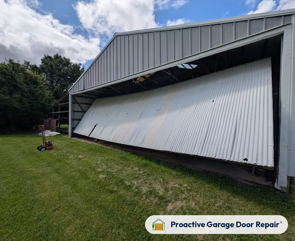 Damaged garage door bent out of its frame on a metal building
