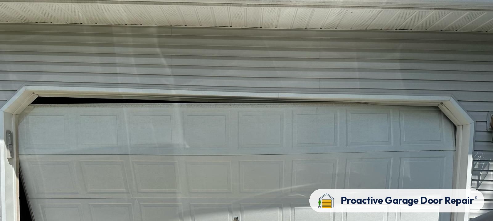 Dented garage door panel before repair