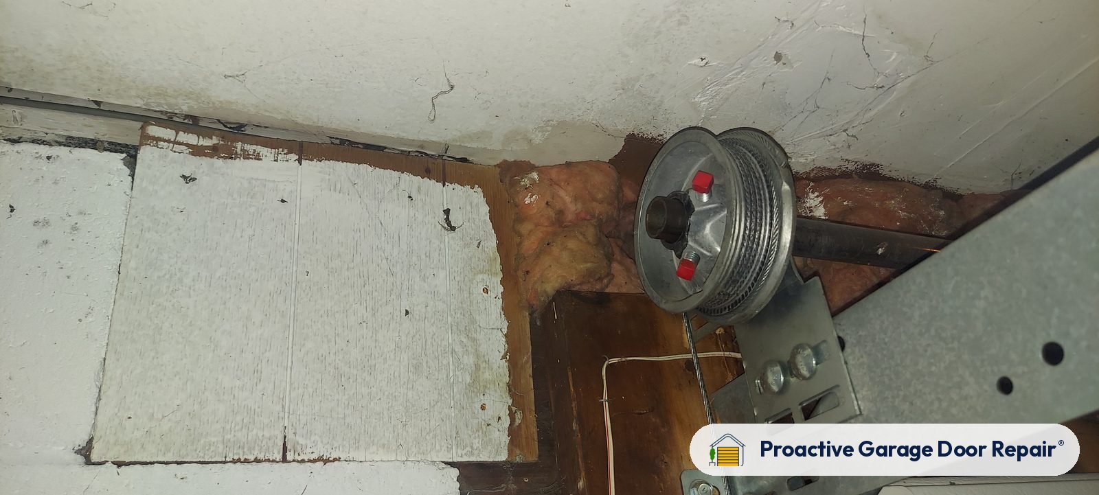 Garage door cable drum and bracket on a garage wall