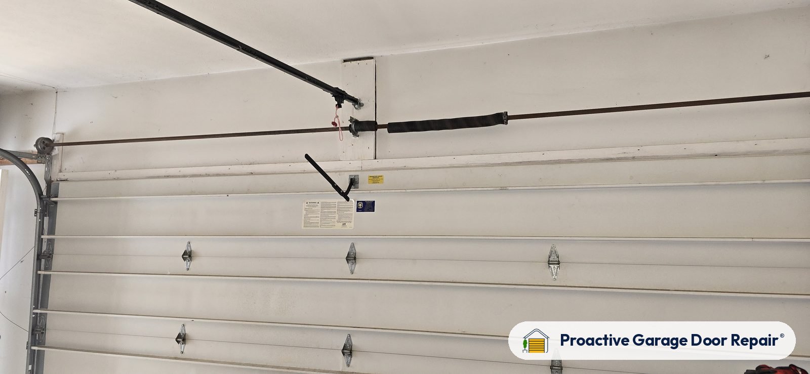 Garage door torsion spring above a white door