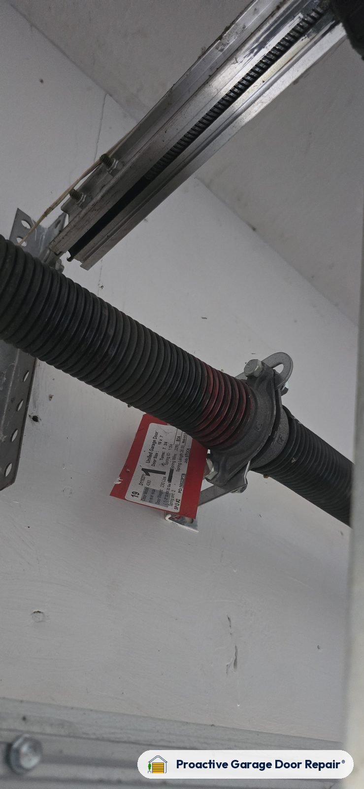 Close-up of a garage door torsion spring and winding cone